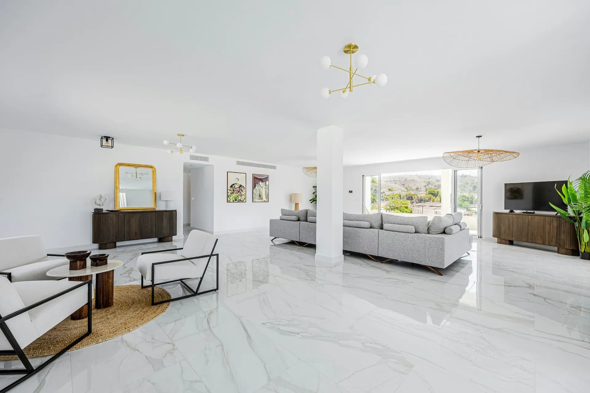Interior de imóvel gerido pela Quinta Prime — sala moderna com lustre dourado