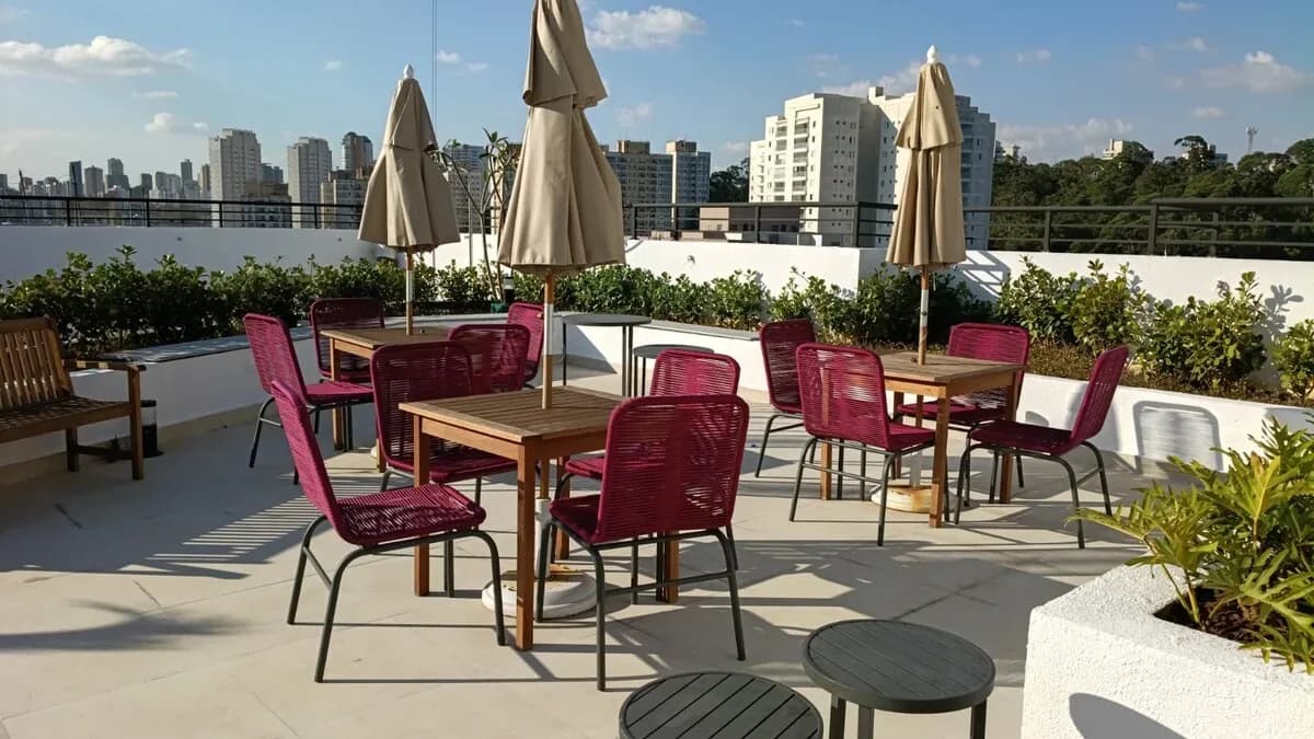 Terraço do condomínio com mesas e vista para o Morumbi, São Paulo