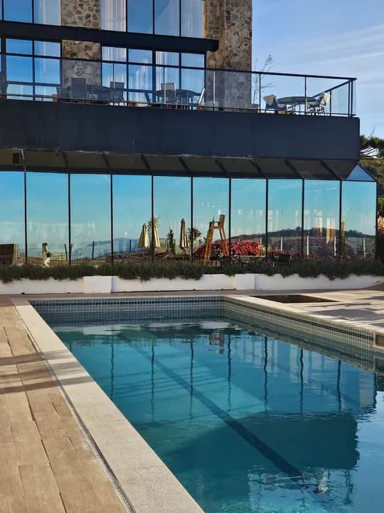 Piscina externa junto à fachada de vidro