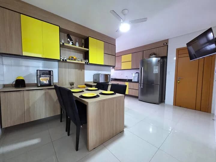 cozinha com mesa para refeições e armários amarelos