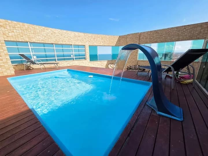 piscina privativa com cascata no deck de madeira