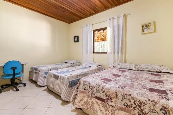 quarto com cama de casal e camas de solteiro