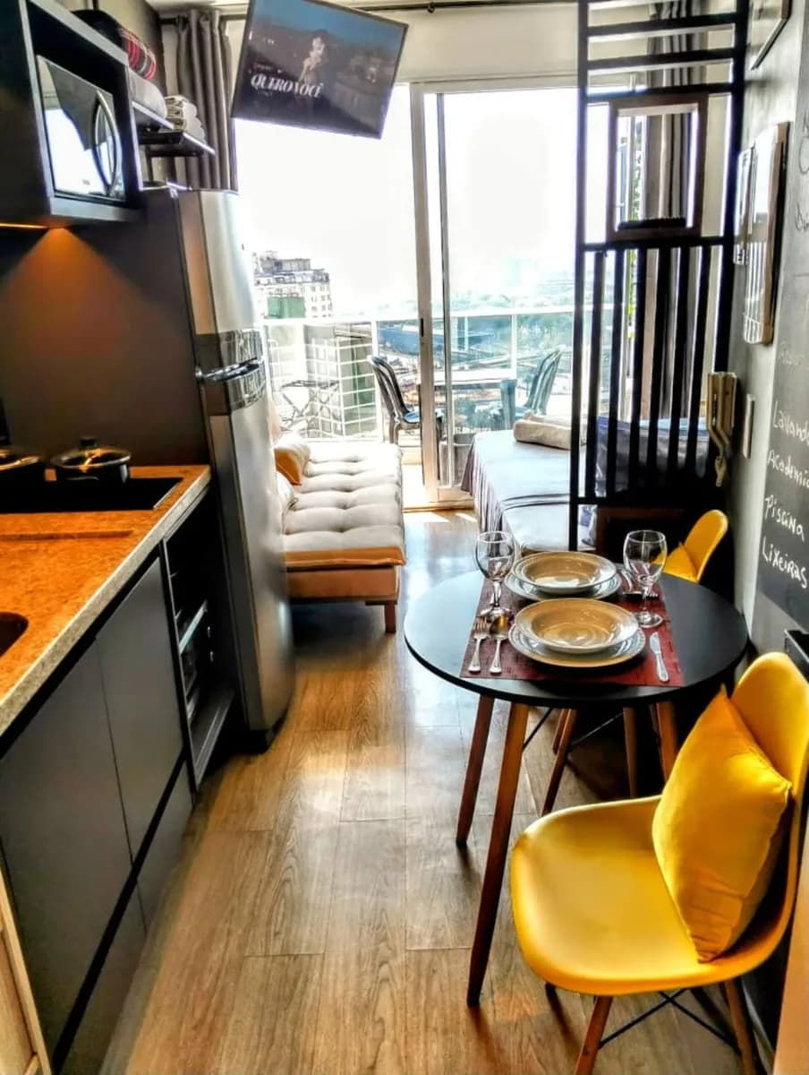 Studio integrado com mesa posta e vista da cidade na Liberdade, São Paulo